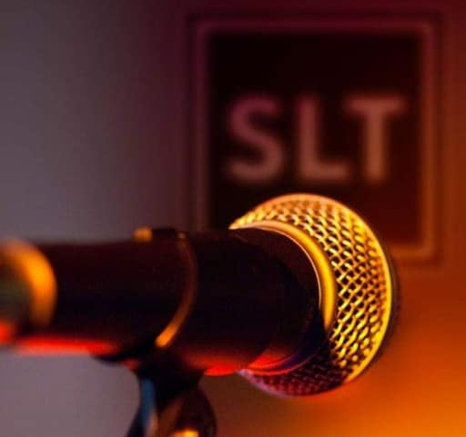 SLT Open Mic image: SLT logo out of focus in the background of a close-up on a microphone in a stand