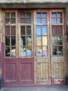 A photograph of the heritage wooden doors that have had 75% of the paint removed.
