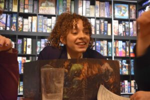 A young woman sits behind part of a Dungeons and Dragons game