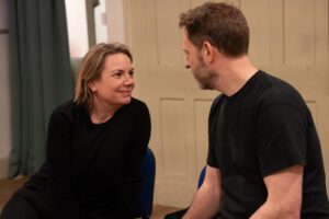 Man and woman sit facing and talking to each other