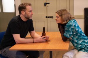Man and woman sit across the table from each other deep in conversation