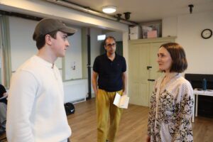 A director stands between two actors facing each other