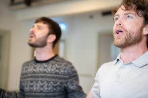 Two actors in rehearsal apparently singing
