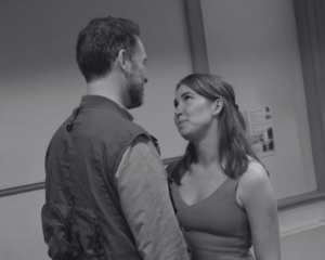 Aman and a woman stand gazing into each other's eyes
