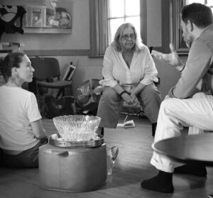 Two actors sit talking with their director