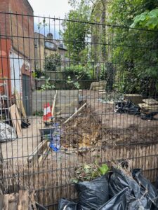 A picture of the yard where the old wall has been removed and the soil is being stabilised.