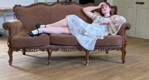 A female actor languishes on a sofa